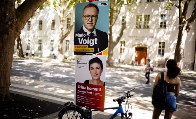 Election campaign posters of the Christian Democratic Union party, CDU, with top candidate Mario Voigt and of the Sahra Wagenknecht Alliance are displayed at a lamp post in Jena, Germany, Aug. 13, 2024. State elections in Thuringia and Saxony scheduled on Sunday Sept. 1, 2024, in the eastern Germany states. (AP Photo/Markus Schreiber)