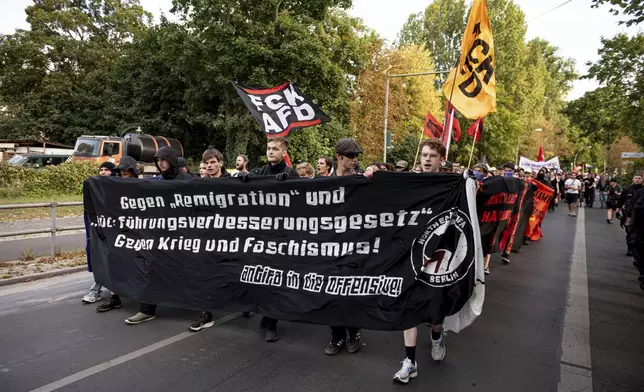 People carry a banner reads "Against "Remigration" and "Repatriation Improvement Act - Against War and Fascism" during a protest against an election party of AfD supporters for the state elections in Saxony and Thuringia, in Berlin, Germany, Sunday, Sept. 1, 2024. (Fabian Sommer/dpa via AP)