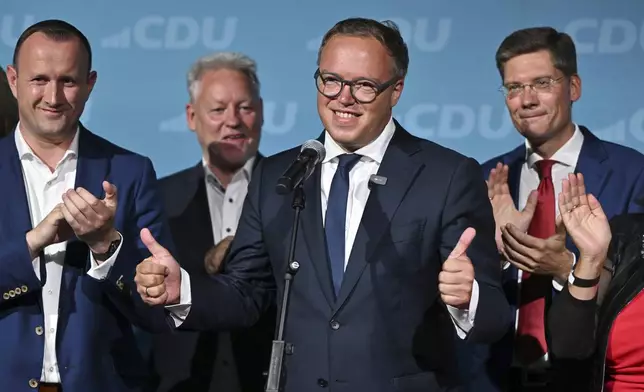 Mario Voigt, center, speaks after the first exit polls for the state elections in Thuringia and Saxony are released, in Erfurt, Germany, Sunday, Sept. 1, 2024. (Martin Schutt/dpa via AP)