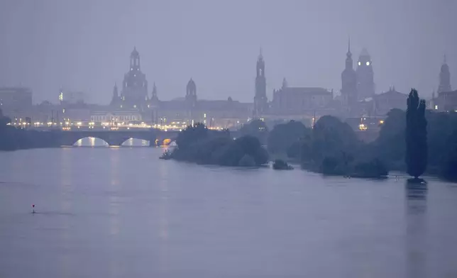 The Elbe floods against the backdrop of the old town at dawn Tuesday, Sept. 17, 2024, in Saxony, Dresden, Germany. (Sebastian Kahnert/dpa via AP)