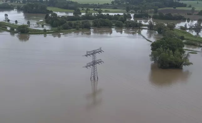 An electricity pylon stands in the flood waters of the Neisse, in the Hagenwerder district of Görlitz, Germany, Monday, Sept. 16, 2024. (Paul Glaser/dpa via AP)