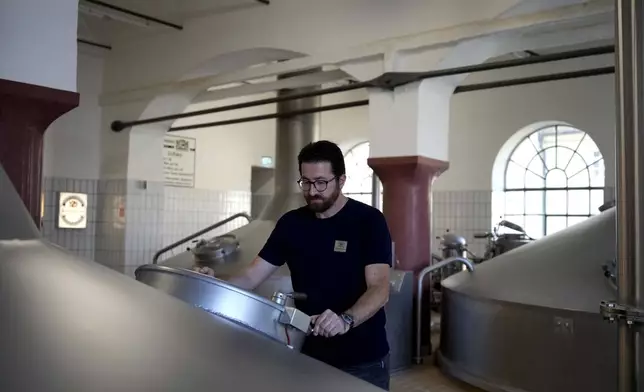 Head Brewmaster Tobias Zollo checks the output at the Weihenstephan brewery in Freising, Germany, Friday, Sept. 20, 2024. (AP Photo/Matthias Schrader)