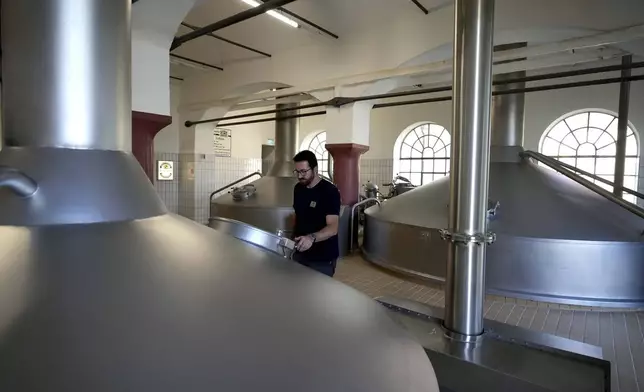 Head Brewmaster Tobias Zollo checks the output at the Weihenstephan brewery in Freising, Germany, Friday, Sept. 20, 2024. (AP Photo/Matthias Schrader)