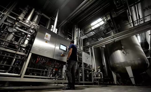 Head Brewmaster Tobias Zollo checks the output at the Weihenstephan brewery in Freising, Germany, Friday, Sept. 20, 2024. (AP Photo/Matthias Schrader)