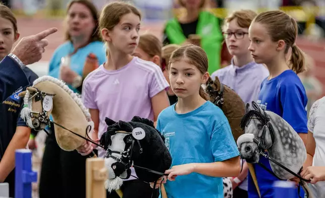 Competitors are instructed during the first German Hobby Horsing Championship in Frankfurt, Germany, Saturday, Sept. 14, 2024. (AP Photo/Michael Probst)