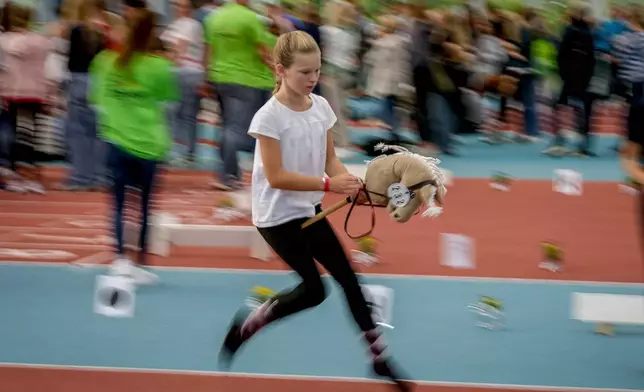 A participant competes in the dressage event at the first German Hobby Horsing Championship in Frankfurt, Germany, Saturday, Sept. 14, 2024. (AP Photo/Michael Probst)