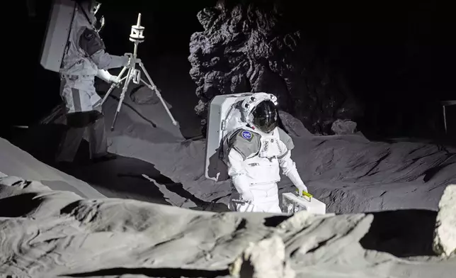 Astronauts Thomas Pesquet of France and Matthias Maurer of Germany demonstrate their training in lunar surface simulating conditions for future moon missions, like the Artemis lunar exploration program led by NASA, at the opening of the new LUNA facility at the European Astronaut Center in Cologne, Germany, Wednesday, Sept. 25, 2024. (AP Photo/Martin Meissner)