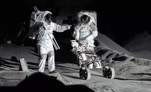 Astronauts Thomas Pesquet of France and Matthias Maurer of Germany demonstrate their training in lunar surface simulating conditions for future moon missions, like the Artemis lunar exploration program led by NASA, at the opening of the new LUNA facility at the European Astronaut Center in Cologne, Germany, Wednesday, Sept. 25, 2024. (AP Photo/Martin Meissner)