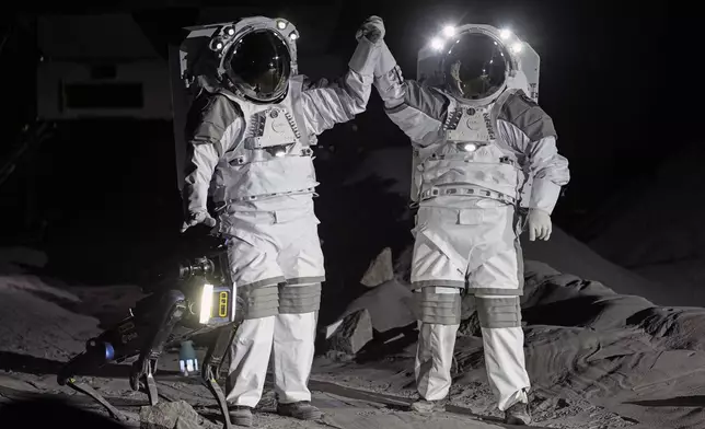 Astronauts Thomas Pesquet of France and Matthias Maurer of Germany demonstrate their training in lunar surface simulating conditions for future moon missions, like the Artemis lunar exploration program led by NASA, at the opening of the new LUNA facility at the European Astronaut Center in Cologne, Germany, Wednesday, Sept. 25, 2024. (AP Photo/Martin Meissner)