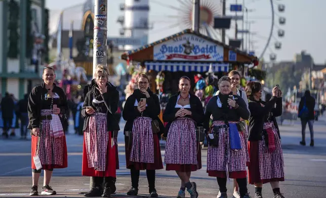 Waitresses wait for the gate opening before the start of the 189th 'Oktoberfest' beer festival in Munich, Germany, Saturday, Sept. 21, 2024. (AP Photo/Matthias Schrader)