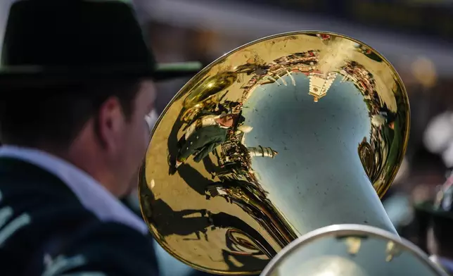 A Bavarian musician mirror in a tuba at the start of the 189th 'Oktoberfest' beer festival in Munich, Germany, Saturday, Sept. 21, 2024. (AP Photo/Matthias Schrader)