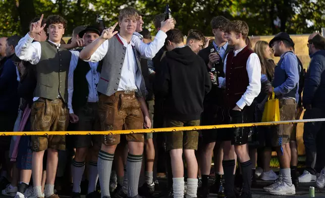 Young visitors await the start of the 189th 'Oktoberfest' beer festival in Munich, Germany, Saturday, Sept. 21, 2024. (AP Photo/Matthias Schrader)