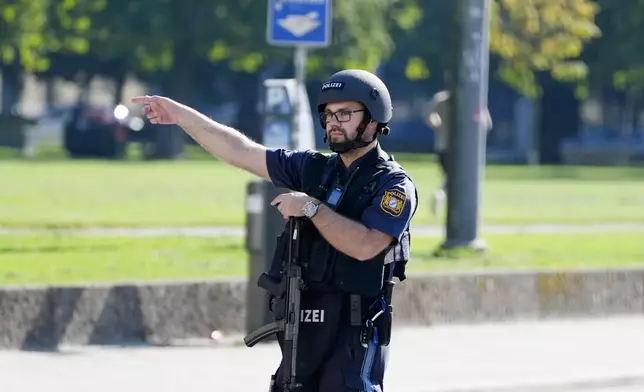 A police officer patrols after police fired shots at a suspicious person near the Israeli Consulate and a museum on the city's Nazi-era history in Munich, Germany, Thursday, Sept. 5, 2024. (AP Photo/Matthias Schrader)