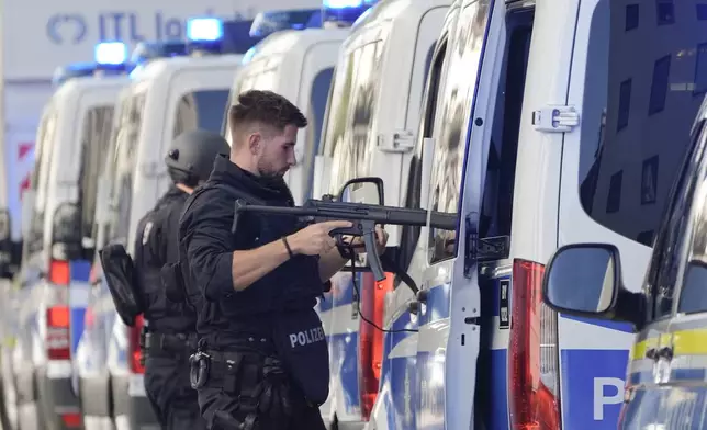 Police officers stand next to their cars after police fired shots at a suspicious person near the Israeli Consulate and a museum on the city's Nazi-era history in Munich, Germany, Thursday, Sept. 5, 2024. (AP Photo/Matthias Schrader)