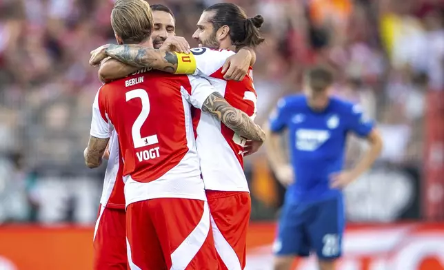 From left, Berlin's Kevin Vogt, Rani Khedira and Christopher Trimmel celebrate after the German Bundesliga soccer match between 1. FC Union Berlin and TSG 1899 Hoffenheim in Berlin, Germany, Saturday, Sept. 21, 2024. (Andreas Gora/dpa via AP)