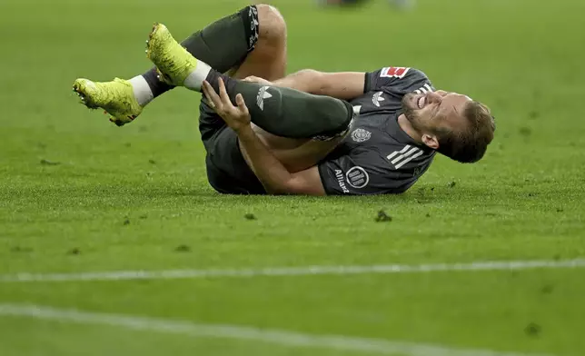 Munich's Harry Kane lies on the pitch in pain during the German Bundesliga soccer match between Bayern Munich and Leverkusen at the Allianz Arena in Munich, Germany, Saturday, Sept. 28, 2024. (Sven Hoppe/dpa via AP)