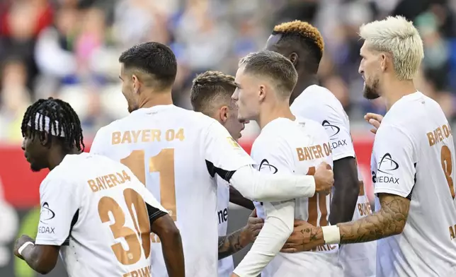 Leverkusen's goalscorer Florian Wirtz, middle celebrates with teammates after scoring during a match between TSG Hoffenheim and Bayer 04 Leverkusen on Saturday, Sept. 14, 2024 in Sinsheim, Germany. (Uwe Anspach/dpa via AP)