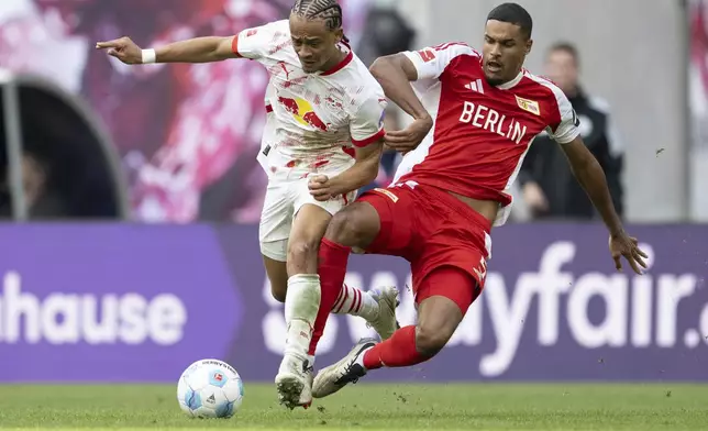 Leipzig's Xavi Simons, left, and Berlin's Danilho Doekhi fight for the ball during a match between RB Leipzig and FC Union Berlin in Leipzig, Germany, Saturday, Sept. 14, 2024. (Hendrik Schmidt/dpa via AP)