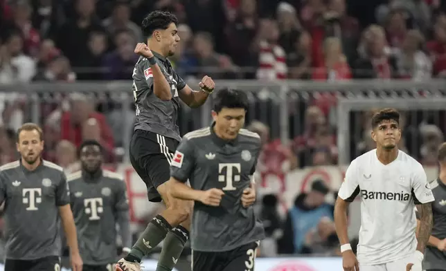 Bayern's Aleksandar Pavlovic celebrates with teammates after scoring his side's first goal during the Bundesliga soccer match between Bayern Munich and Leverkusen at the Allianz Arena in Munich, Germany, Saturday, Sept. 28, 2024. (AP Photo/Matthias Schrader)