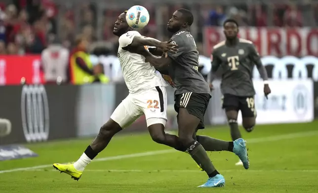 Leverkusen's Victor Boniface, left, and Bayern's Dayot Upamecano vie for the ball during the Bundesliga soccer match between Bayern Munich and Leverkusen at the Allianz Arena in Munich, Germany, Saturday, Sept. 28, 2024. (AP Photo/Matthias Schrader)