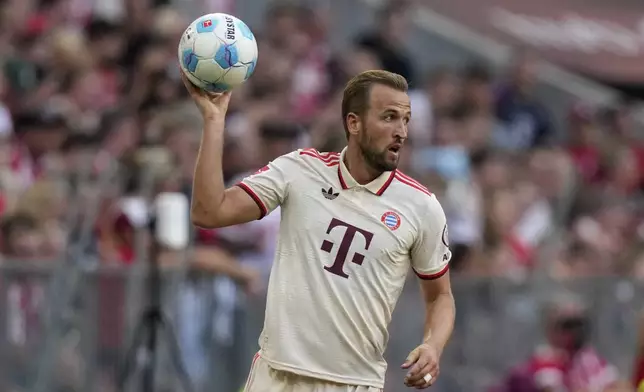 Bayern's Harry Kane prepares to throw the ball during the Bundesliga soccer match between Bayern Munich and SC Freiburg at the Allianz Arena in Munich, Germany, Sunday, Sept. 1, 2024. (AP Photo/Matthias Schrader)