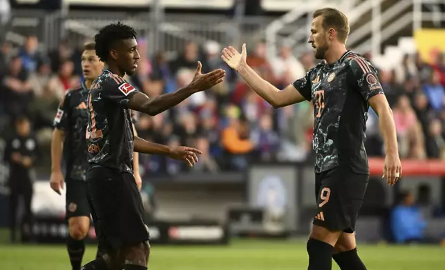 Bayern's Harry Kane, right, is congratulated by Kingsley Coman after scoring during the German Bundesliga soccer match between Holstein Kiel and Bayern Munich, at the Holsten stadium in Kiel, Germany, Saturday, Sept. 14, 2024. (Gregor Fischer/dpa via AP)