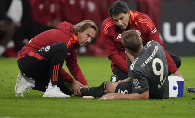 Bayern's Harry Kane is treated during the Bundesliga soccer match between Bayern Munich and Leverkusen at the Allianz Arena in Munich, Germany, Saturday, Sept. 28, 2024. (AP Photo/Matthias Schrader)