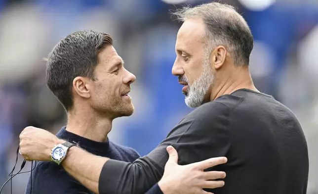 Hoffenheim coach Pellegrino Matarazzo, right, and Leverkusen's head coach Xabi Alonso greet each other before a match between TSG Hoffenheim and Bayer 04 Leverkusen on Saturday, Sept. 14, 2024 in Sinsheim, Germany. (Uwe Anspach/dpa via AP)