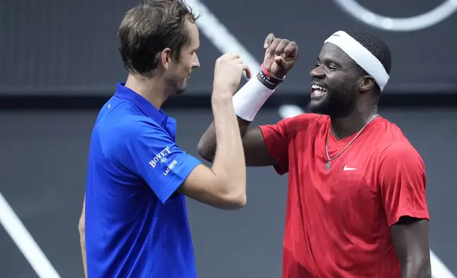 Team World's Frances Tiafoe, right, shares a light moment with Team Europe's Daniil Medvedev on the second day of the Laver Cup tennis tournament at the Uber arena in Berlin, Germany, Saturday, Sept. 21, 2024. (AP Photo/Ebrahim Noroozi)