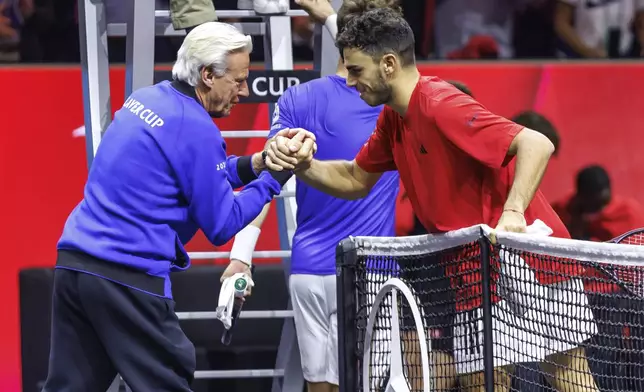 Argentina's Francisco Cerundolo says goodbye to captain Björn Borg after winning his match against Norway's Casper Ruud during their men's singles Laver Cup tennis match at the Uber Arena in Berlin, Germany, Friday Sept. 20, 2024. (Andreas Gora/dpa via AP)