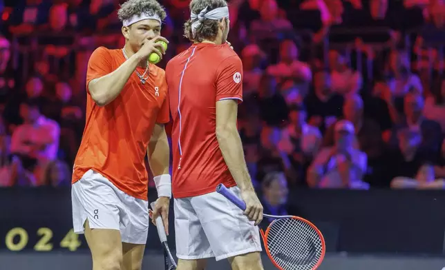 Team World's Ben Shelton, left, and Taylor Fritz confer during a doubles match against Team Europe's Carlos Alcaraz and Alexander Zverev on the first day of the Laver Cup tennis tournament at the Uber arena in Berlin, Germany, Friday, Sept. 20, 2024. (Andreas Gora/dpa via AP)