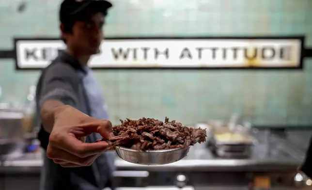 A doner chef prepares doner kebabs for customers in a doner kebab restaurant in Berlin, Germany, Monday, Sept. 16, 2024. (AP Photo/Ebrahim Noroozi)