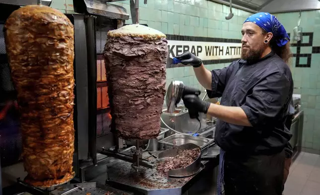 Doner chef Hvesley Silva cuts doner kebab in a doner kebab restaurant in Berlin, Germany, Monday, Sept. 16, 2024. (AP Photo/Ebrahim Noroozi)