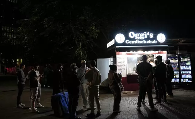 People stand in the line to buy doner kebab in Berlin, Germany, Wednesday, Sept. 18, 2024. (AP Photo/Ebrahim Noroozi)