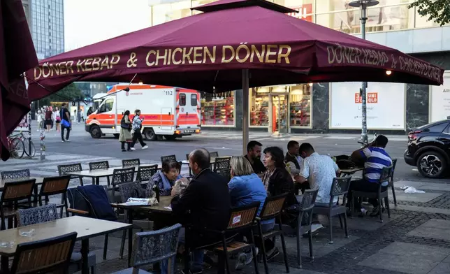 People eat doner in the outdoor area of a doner kebab restaurant in Berlin, Germany, Wednesday, Sept. 18, 2024. (AP Photo/Ebrahim Noroozi)