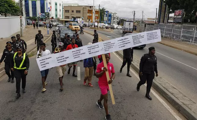 Texas Kadri Moro, the Executive Director of Arise for Justice International, protests with placards nailed on a cross on the street of Accra, Ghana, Thursday Sept 12, 2024. Texas Kadiri Moro is an unusual figure amid the LGBTQ+ rights activists in the coastal West African nation of Ghana. He is heterosexual, married to a woman and a father of six. He is a teacher. And he is a practising Muslim. (AP Photo/Misper Apawu)