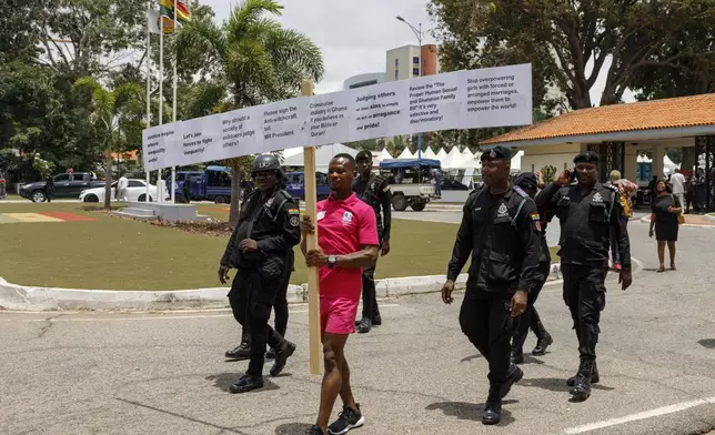 Texas Kadri Moro, the Executive Director of Arise for Justice International, protests with placards nailed on a cross on the street of Accra, Ghana, Thursday Sept 12, 2024. Texas Kadiri Moro is an unusual figure amid the LGBTQ+ rights activists in the coastal West African nation of Ghana. He is heterosexual, married to a woman and a father of six. He is a teacher. And he is a practising Muslim. (AP Photo/Misper Apawu)