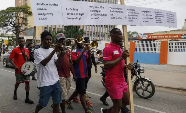 Texas Kadri Moro, the Executive Director of Arise for Justice International, protests with placards nailed on a cross on the street of Accra, Ghana, Thursday Sept 12, 2024. Texas Kadiri Moro is an unusual figure amid the LGBTQ+ rights activists in the coastal West African nation of Ghana. He is heterosexual, married to a woman and a father of six. He is a teacher. And he is a practising Muslim. (AP Photo/ Misper Apawu)