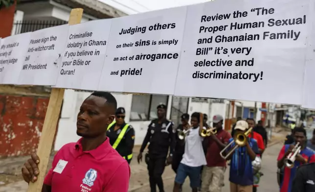 Texas Kadri Moro, the Executive Director of Arise for Justice International, protests with placards nailed on a cross on the street of Accra, Ghana, Thursday Sept 12, 2024. Texas Kadiri Moro is an unusual figure amid the LGBTQ+ rights activists in the coastal West African nation of Ghana. He is heterosexual, married to a woman and a father of six. He is a teacher. And he is a practising Muslim. (AP Photo/Misper Apawu)