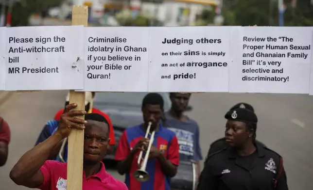 Texas Kadri Moro, the Executive Director of Arise for Justice International, protests with placards nailed on a cross on the street of Accra, Ghana, Thursday Sept 12, 2024. Texas Kadiri Moro is an unusual figure amid the LGBTQ+ rights activists in the coastal West African nation of Ghana. He is heterosexual, married to a woman and a father of six. He is a teacher. And he is a practising Muslim. (AP Photo/Misper Apawu)