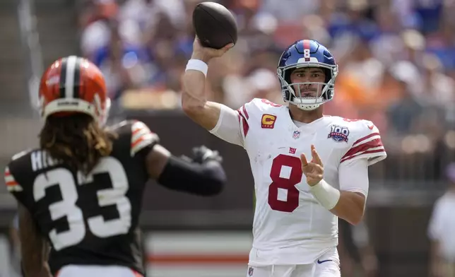 New York Giants quarterback Daniel Jones (8) passes as Cleveland Browns safety Ronnie Hickman (33) applies pressure during the first half of an NFL football game, Sunday, Sept. 22, 2024 in Cleveland. (AP Photo/Sue Ogrocki)