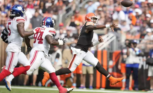 Cleveland Browns quarterback Deshaun Watson, right, passes against the New York Giants during the second half of an NFL football game, Sunday, Sept. 22, 2024, in Cleveland. (AP Photo/Sue Ogrocki)