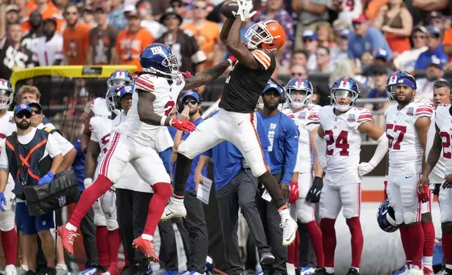 Cleveland Browns wide receiver Amari Cooper, foreground right, catches a pass against New York Giants cornerback Deonte Banks during the second half of an NFL football game, Sunday, Sept. 22, 2024, in Cleveland. (AP Photo/Sue Ogrocki)