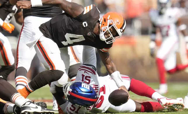 New York Giants linebacker Azeez Ojulari, bottom, sacks Cleveland Browns quarterback Deshaun Watson (4) during the second half of an NFL football game, Sunday, Sept. 22, 2024, in Cleveland. (AP Photo/Sue Ogrocki)