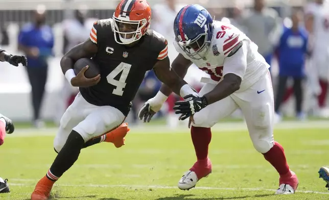 Cleveland Browns quarterback Deshaun Watson (4) runs against New York Giants defensive tackle Elijah Chatman during the second half of an NFL football game, Sunday, Sept. 22, 2024, in Cleveland. (AP Photo/Sue Ogrocki)