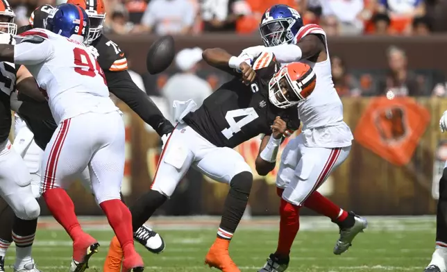 New York Giants linebacker Brian Burns, right, forces Cleveland Browns quarterback Deshaun Watson (4) to fumble the ball, which the Giants recovered, during the first half of an NFL football game, Sunday, Sept. 22, 2024 in Cleveland. (AP Photo/David Richard)