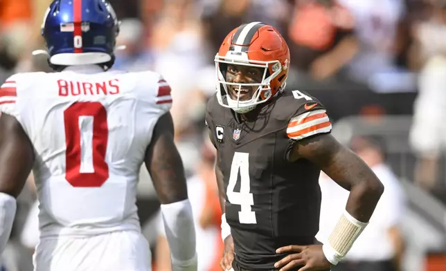 Cleveland Browns quarterback Deshaun Watson (4) reacts after throwing a touchdown pass next to New York Giants linebacker Brian Burns (0) during the second half of an NFL football game, Sunday, Sept. 22, 2024, in Cleveland. (AP Photo/David Richard)