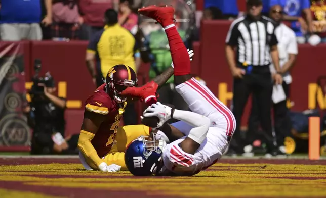 New York Giants wide receiver Malik Nabers, front, catches a touchdown pass against the Washington Commanders during the first half of an NFL football game in Landover, Md., Sunday, Sept. 15, 2024. (AP Photo/Steve Ruark)