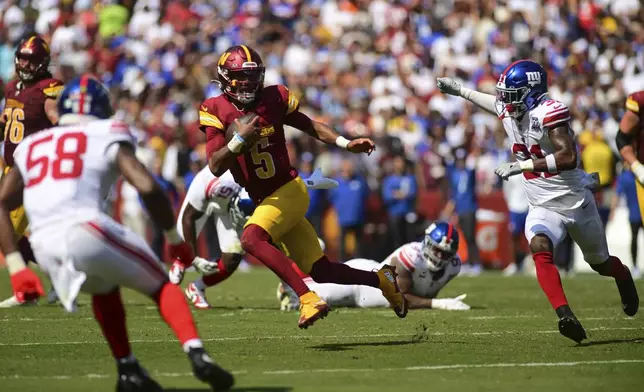 Washington Commanders quarterback Jayden Daniels (5) runs as New York Giants safety Tyler Nubin and Bobby Okereke (58) pursue during the first half of an NFL football game in Landover, Md., Sunday, Sept. 15, 2024. (AP Photo/Steve Ruark)