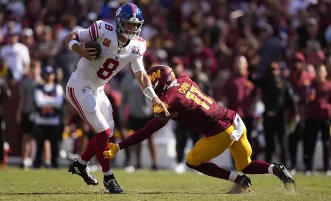 New York Giants quarterback Daniel Jones (8) is tackled by Washington Commanders safety Jeremy Chinn (11) during the second half of an NFL football game in Landover, Md., Sunday, Sept. 15, 2024. (AP Photo/Matt Slocum)